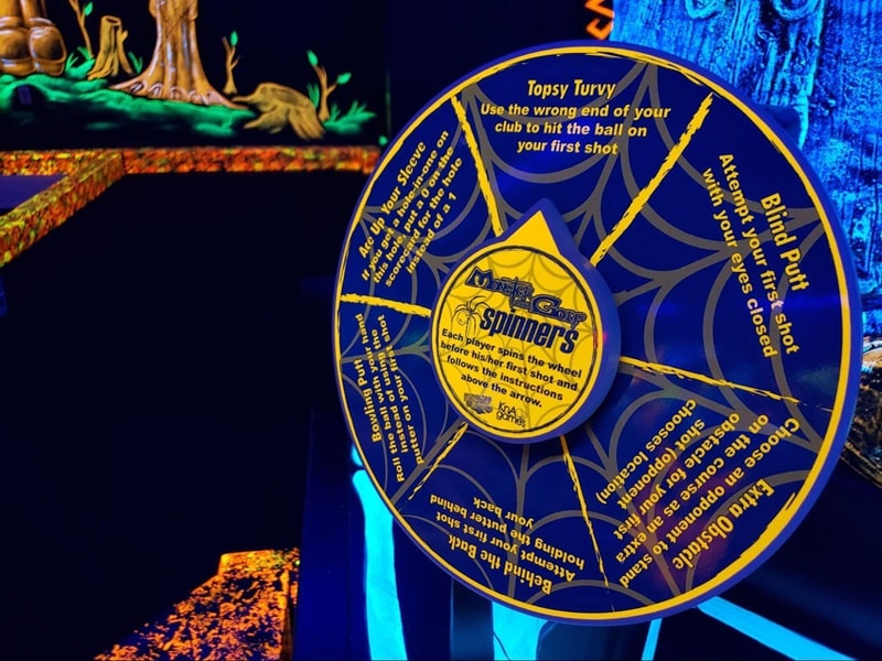 A spinner with different challenges at a Monster Mini Golf location. 