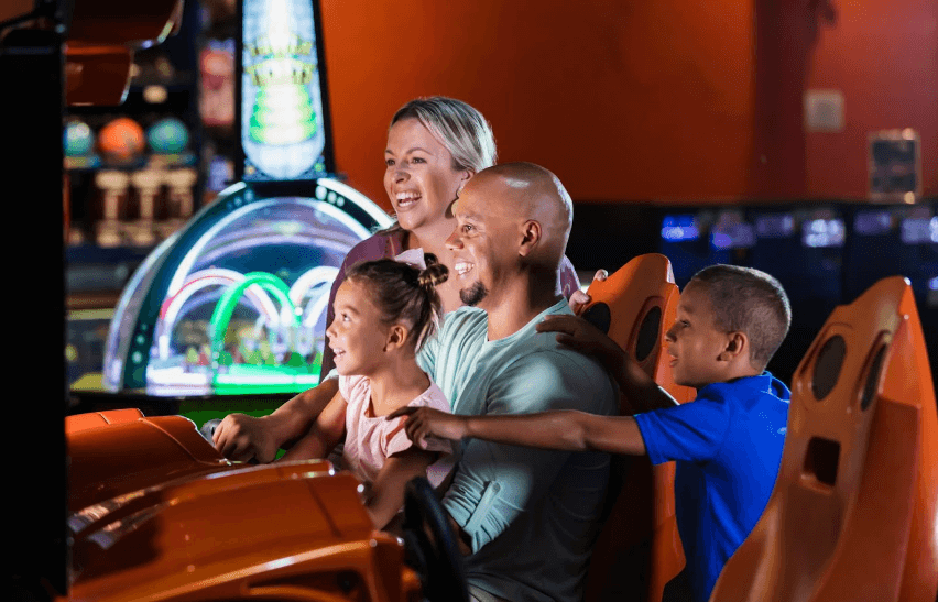 family playing games at arcade in monster mini golf