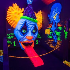 glowing clown head on a putt putt course at monster mini golf