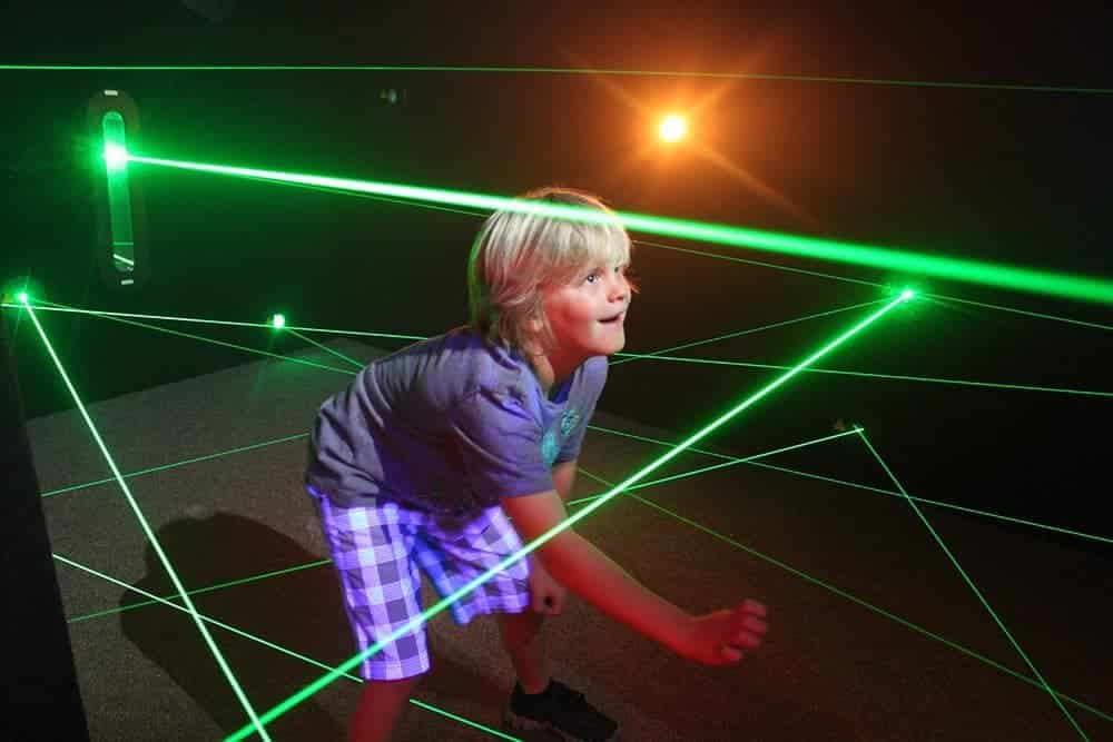 kid playing in a laser maze