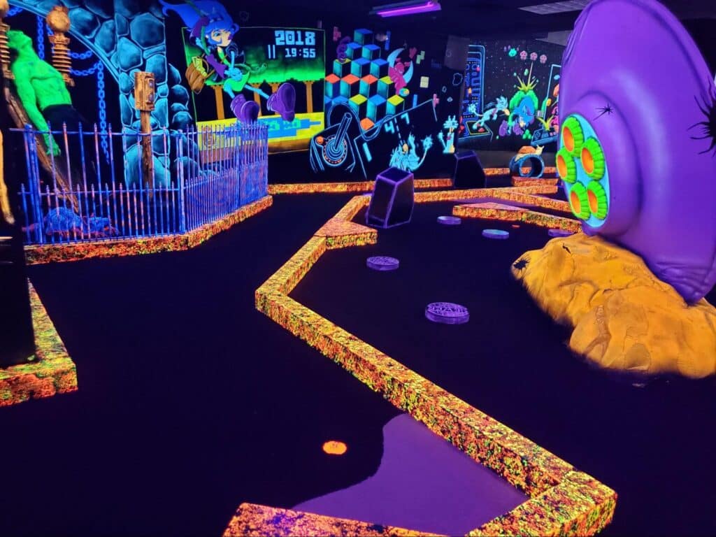 A neon, glow-in-the-dark indoor mini golf course at Monster Mini Golf.