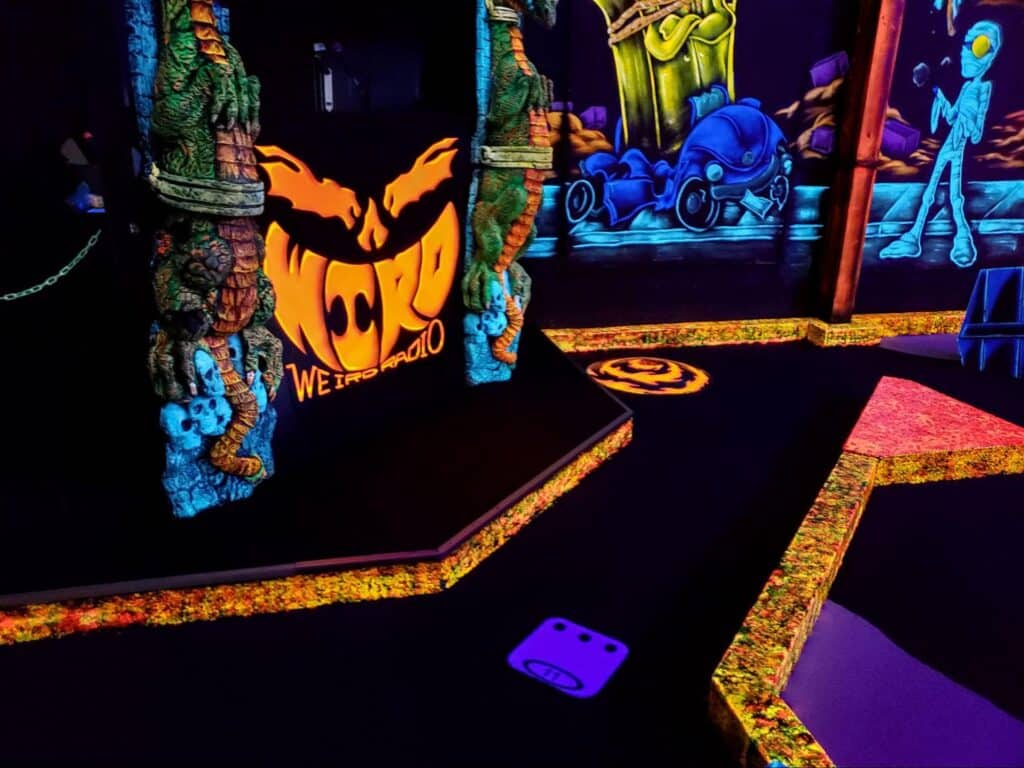 Neon decorations surrounding the glow-in-the-dark mini golf course at Monster Mini Golf.