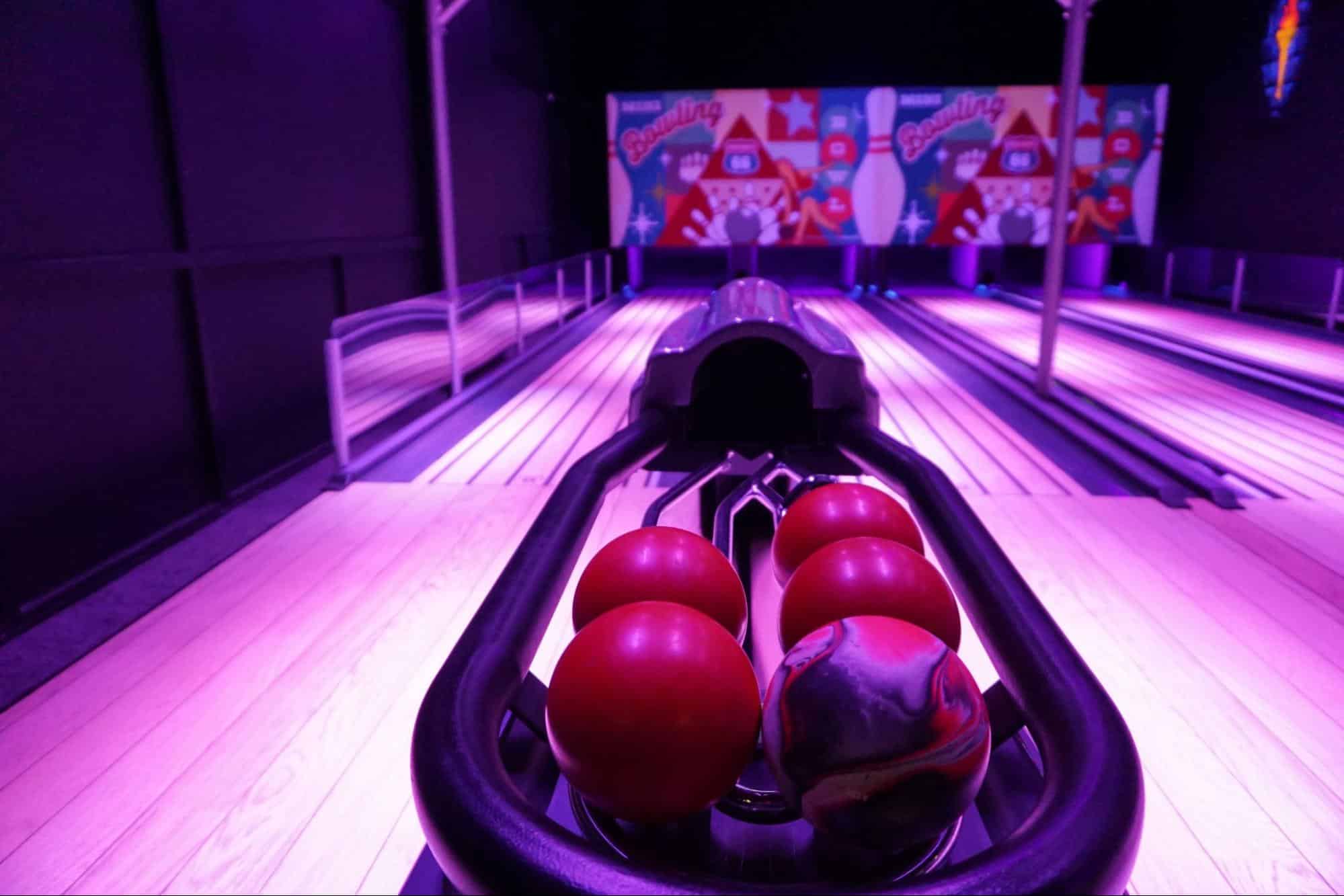 Neon mini bowling lanes with mini bowling balls at Monster Mini Golf.