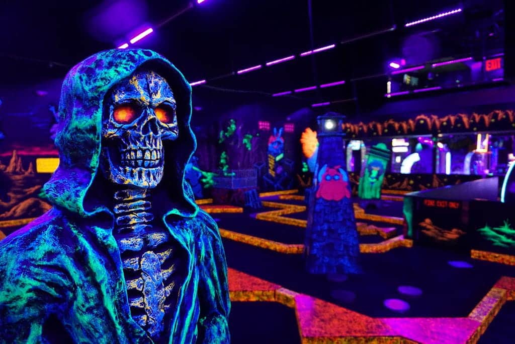 A glow-in-the-dark skeleton decoration at an indoor Monster Mini Golf location.
