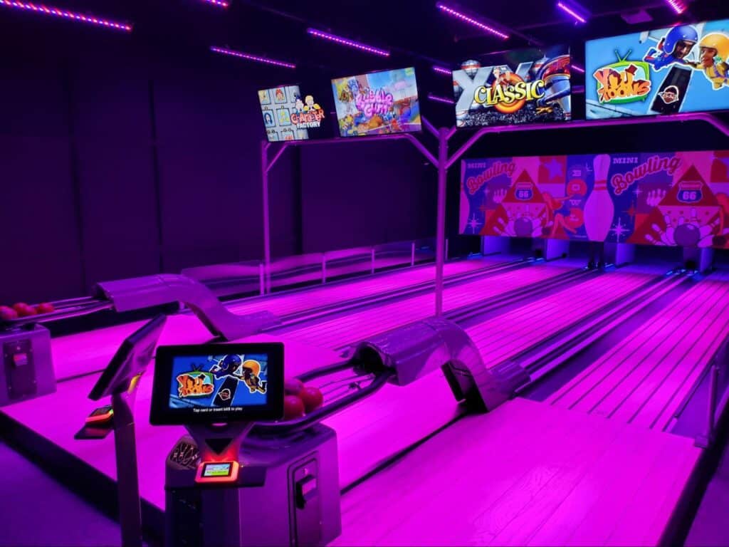 Neon pink mini bowling lanes at a Monster Mini Golf location. 