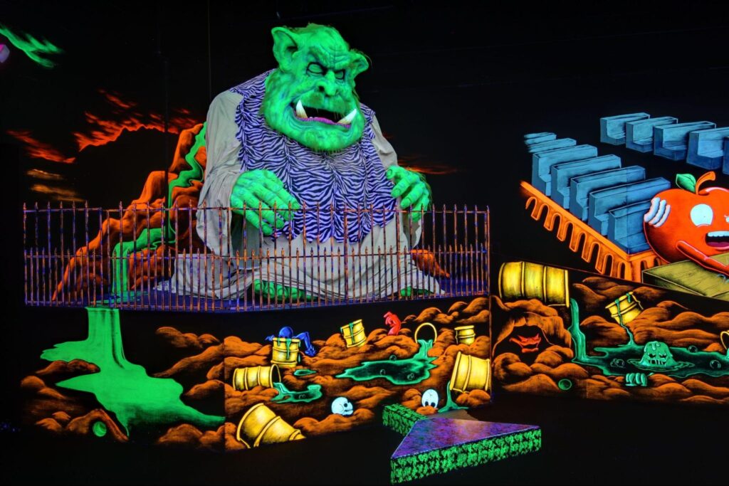 A neon monster decoration at a monster mini golf location.