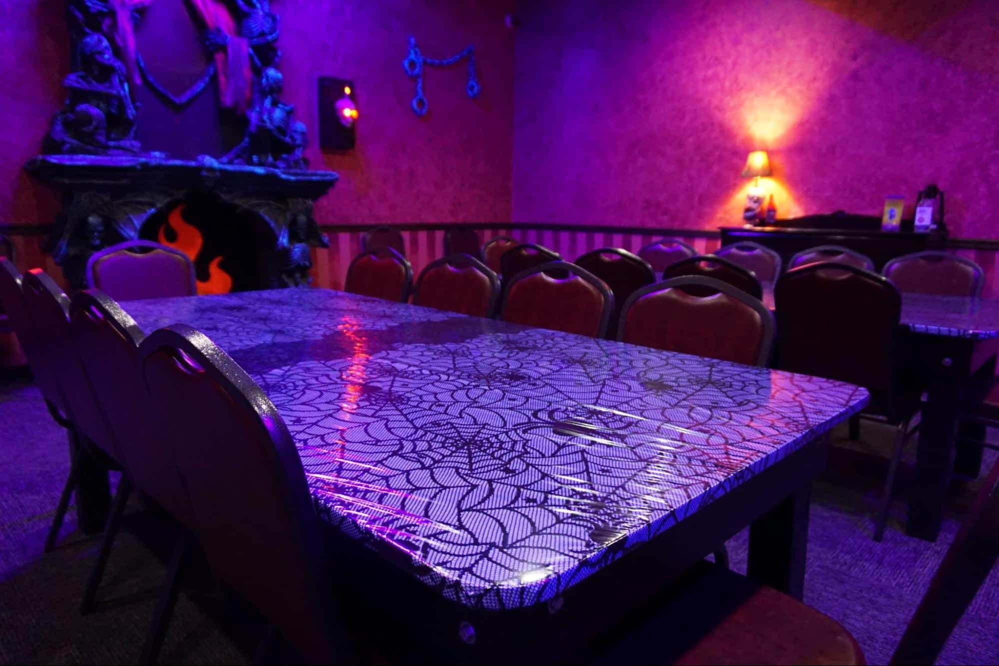 A private haunted mansion room decorated for a birthday party at a monster mini golf location.