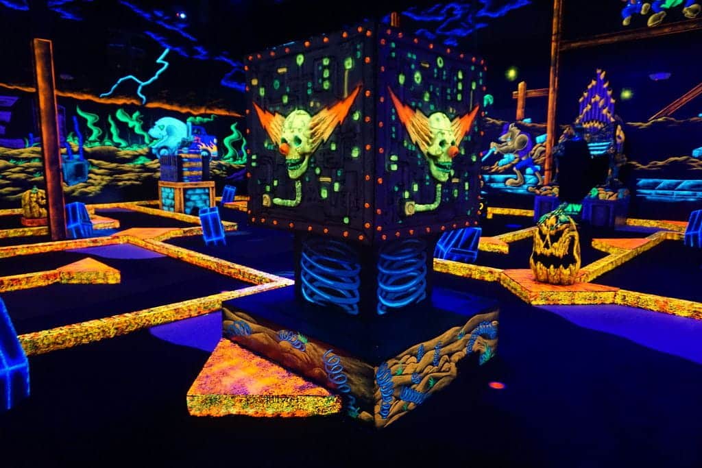 Neon decorations on an indoor golf course at a Monster Mini Golf location.