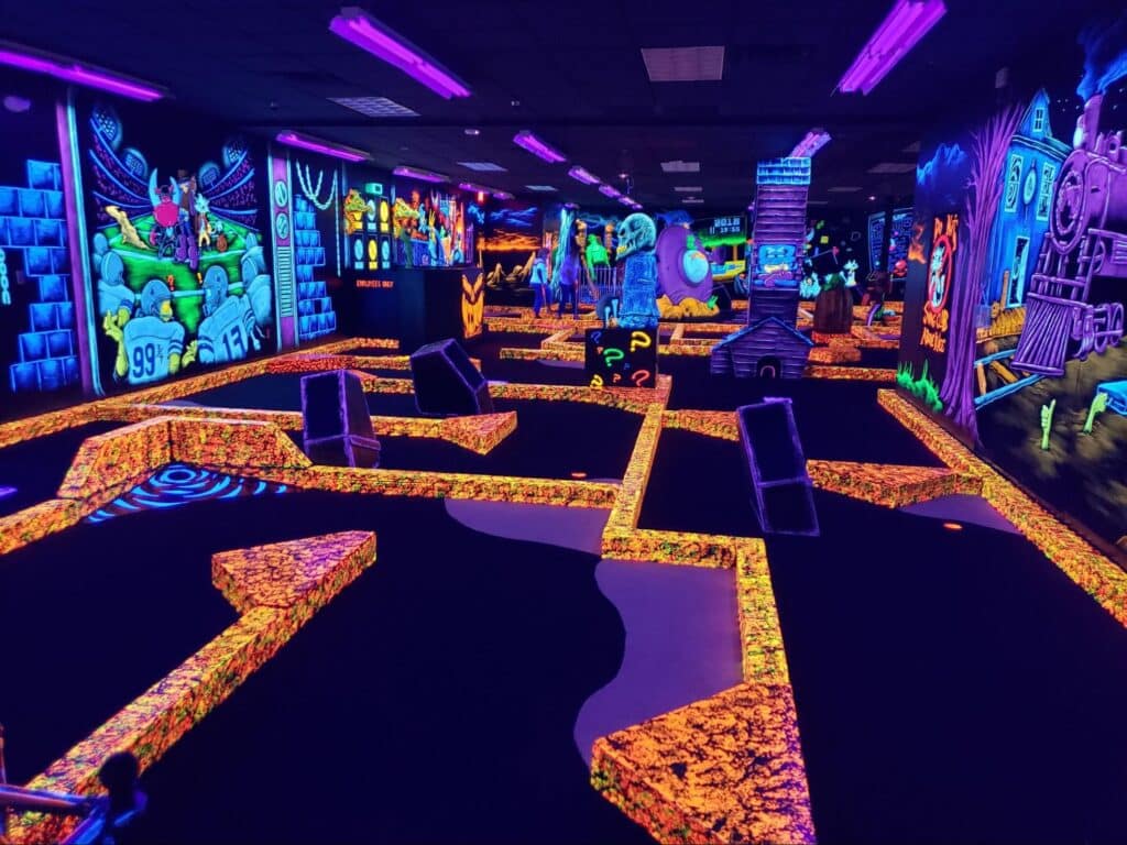 Neon decorations at a glow-in-the-dark indoor golf course at a Monster Mini Golf location.